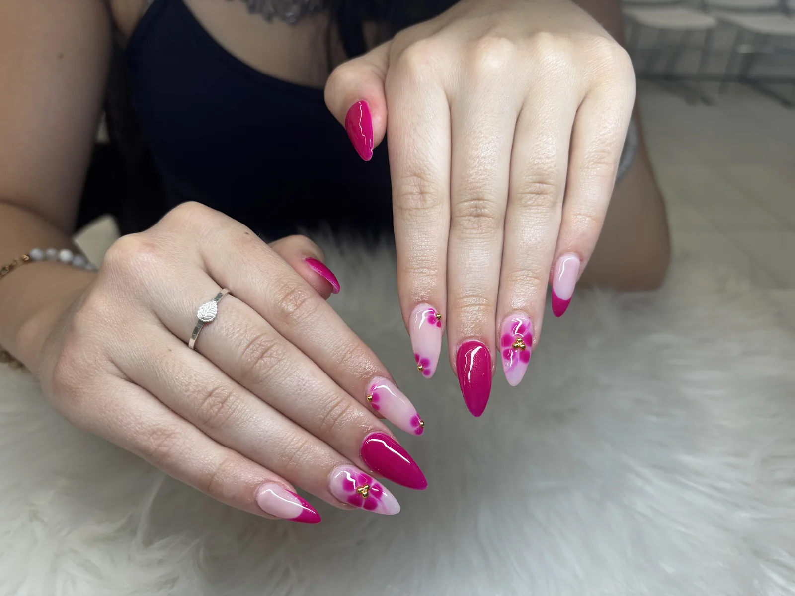 Pink almond nails with delicate floral accents by Top Ten Nails Spa
